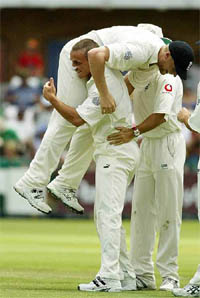 England bowler Simon Jones carries his teammate Andrew Flintoff