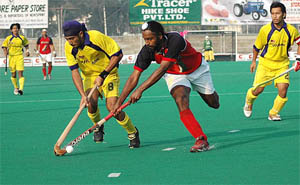 Baljit Singh Dhillon of Punjab Police tackles a Malaysian XI player during a match of the All-India Ramesh Chander Hockey Tournament in Jalandhar on Saturday.