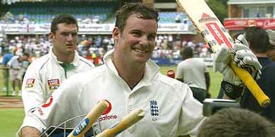 England's batsman Andrew Strauss raises his bat as he leaves the field followed by the defeated South Africa's captain Graeme Smith at the end of a first Test on Tuesday