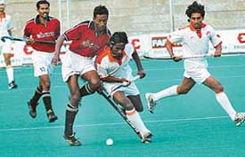 Hockey players of Indian Airlines and BSF engaged in a tussle to gain possession of ball in the All-India Ramesh Chander Hockey Tournament in Jalandhar on Tuesday