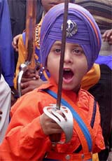 A Nihang boy brandishes a sword during the nagar kirtan