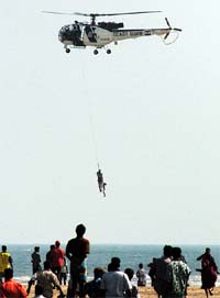 A Coast Guard helicopter airlifts a fisherman from Marina beach after a tsunami triggered by an earthquake in the Indian Ocean hit the area in Chennai