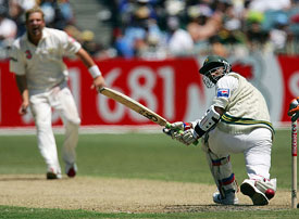 Pakistan's Yousuf Youhana  plays a sweep shot as Australia's Shane Warne looks on during the first innings of the second Test 