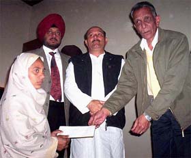 PSEB Chairman Y.S. Ratra hands over a cheque to a widow during the launching of several schemes for the welfare of the board employees in Patiala