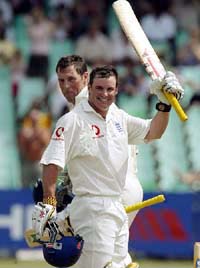 England opener Andrew Strauss celebrates his century as partner Marcus Trescothick walks by