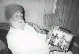 This photo of Bakhtawar Singh was taken by the writer at Port Blair in 1994. He shows an old photo of him dancing with the Jawaras.