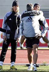 Real Madrid�s Brazilian soccer star Ronaldo carries a trainer in front of team-mate Guti during a training session in Madrid