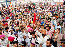 Activists of the FCI Workers Union stage dharna outside the city I police station in Moga on Saturday.