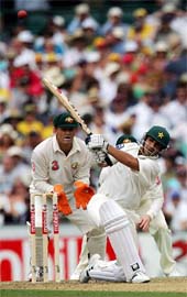 Pakistan�s Salman Butt hits a boundary as Australia�s Adam Gilchrist looks on during the first day of the third Test in Sydney on Sunday. 