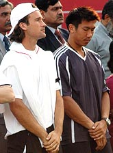 Carlos Moya of Spain and Paradorn Srichaphan of Thailand observe a moment's silence for tsunami victims