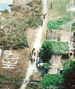 Tsunami victims from Hut Bay stand next to the word ‘HELP’ inscribed on the ground in the Andaman and Nicobar islands.