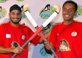 Indian ace off spinner Harbhajan Singh Bhajji and international Gagan Ajit Singh hold sticks across during a press conference in Jalandhar on Thursday