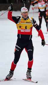 Raphael Poiree of France celebrates as he crosses the finish line to win the Biathlon