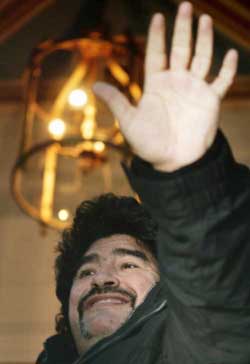 Argentine soccer legend Diego Maradona waves to reporters in Athens on Thursday