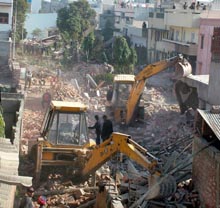 An MC demolition squad pulls down illegal structures along the purani nahar in Jalandhar on Friday. 