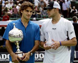 World number one Roger Federer of Switzerland holds the trophy as he stands next to Andy Roddick of the USA after winning the Kooyong Classic tennis tournament in Melbourne on Saturday