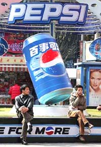 Chinese shoppers rest near a Pepsi advertisement in Shanghai