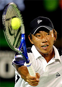 Takao Suzuki from Japan hits a volley during his second round match against world number one Roger Federer from Switzerland 