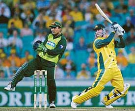 Michael Clarke of Australia plays a shot as Pakistani wicketkeeper Kamram Akmal watches during their one-day international match in Sydney on Sunday