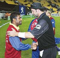 Muttiah Muralitharan of World XI shakes hands with New Zealand's Chris Cairns after their one-day international cricket match in Wellington on Monday