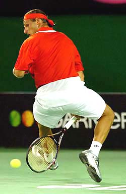 David Nalbandian of Argentina makes a return between legs during his fourth round match against compatriot Guillermo Coria, in Melbourne on Monday