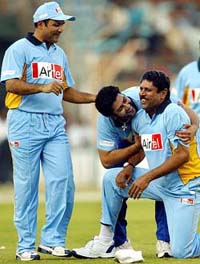 Bollywood star Aftab Shivdasani congratulates former Indian captain Kapil Dev for taking a catch while Virender Sehwag looks on during a tsunami fund-raising match between Aamir Khan XI and Kapil Dev XI