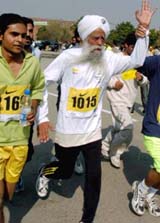 Fauja Singh, right, 94, of India, runs during the Lahore International Marathon 2005 in Lahore
