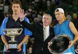 Legendary Australian tennis star Ken Rosewall waves to the crowd after presenting Russia's Marat Safin and Australia's Lleyton Hewitt with the winner's and runner-up trophies