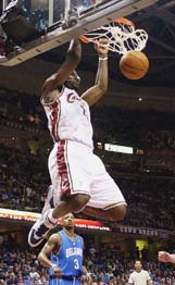 LeBron James of the Cleveland Cavaliers dunks as Steve Francis of the Orlando Magic looks on