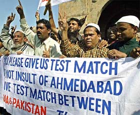 Muslims flash the victory sign on Wednesday as they urge Pakistan to play their Test match in Ahmedabad