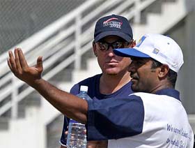 Sri Lanka's Muttiah Muralitharan explains to Australia's Shane Warne on how the tsunami waves hit the Galle international cricket stadium in southern Sri Lanka
