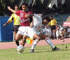 Mohun Bagan striker Ashim Biswas being challenged by a State Bank of Travancore defender 