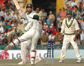 Kamran Akmal attempts a stumping off the bowling of Danish Kaneria  to dismiss V.V.S. Laxman as Asim Kamal looks on