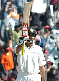 Indian batsman VVS Laxman raises his bat on completing his fifty on the fourth day of the first Test in Mohali on Friday