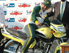 Kamran Akmal sits on a TVS Victor motor cycle after being declared the man of the match on the fifth day of the Mohali Test on Saturday