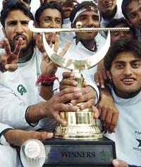 Pakistani hockey players pose with the trophy after winning the four-nation junior hockey tournament in Lahore on Sunday