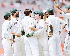 Shahid Afridi is congratulated by his team-mates after the dismissal of Virender Sehwag