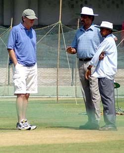 Indian cricket team coach John Wright  talking about the pitch to Narayan Raju (C), pitch curator at Chinaswamy Stadium in Bangalore on Monday