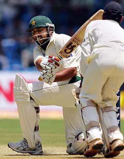 Pakistan's captain Inzamam-ul-Haq (L) plays a stroke as India's wicketkeeper Dinesh Karthik watches during the first day's play of the third Test match in Bangalore 