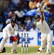 Pakistan�s Younis Khan plays a shot as Indian wicketkeeper Dinesh Kaarthick looks on during the fourth day of the third Test against India in Bangalore on Sunday
