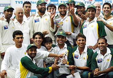 Members of the Pakistan cricket team pose with the trophy after winning the third Test against India to level the series 1-1 in Bangalore on Monday