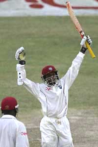 West Indies captain Shivnarine Chanderpaul raises his bat after completing his century against South Africa on the opening day of the first Test in Georgetown on Thursday