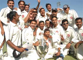 The jubilant Railways team with the trophy after defeating Punjab in the Ranji Trophy Elite group final in Mohali