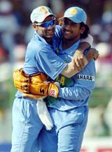 Indian cricketer Mahendra Dhoni holds a wicket as he walks with team mate Mohammad Kaif after India won the second one-day international against Pakistan in Visakhapatnam
