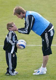 Real Madrid player David Beckham speaks with his son Brooklyn