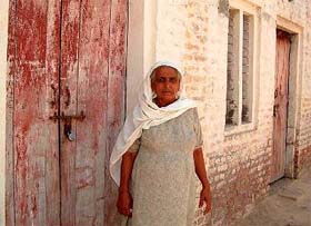 Balbir Kaur stands in front of her locked house at Dhobiana Basti in Bathinda