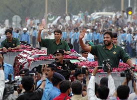 Pakistan captain Inzamam-ul-Haq (R) waves to the crowd during a mass welcome in Islamabad