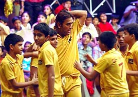 India's latest cricket sensation Mahendra Singh Dhoni interacts with children during the shooting of a cricket show in Mumbai on Monday