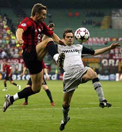 Andriy Shevchenko of AC Milan challenges Phillip Cocu of PSV Eindhoven for the ball during their Champions League semifinal first-leg match at the San Siro stadium in Milan, Italy