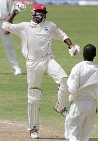 West Indies batsman Chris Gayle celebrates his century while South Africa fast bowler Monde Zondeki looks on